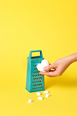 Image showing Kitchen grater and plaster heart in a woman\'s hand.