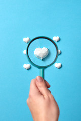 Image showing Focused plaster heart in a magnifying glass in the hand.