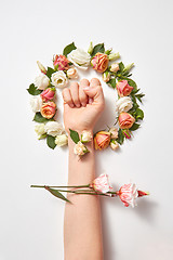 Image showing Fresh natural flowers wreath with female\'s hand.