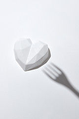 Image showing White plaster heart with hard shadow from fork.