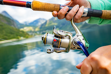 Image showing Woman fishing on Fishing rod spinning in Norway.