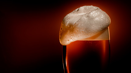 Image showing Lager beer settles in the glass with a white cap of foam