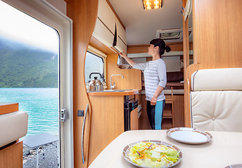 Image showing Woman cooking in camper, motorhome interior