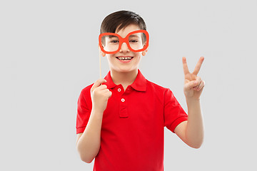 Image showing smiling boy with big paper glasses showing peace