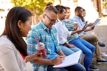 Image showing group of happy students with notebook and drinks