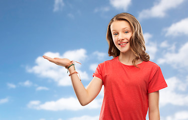 Image showing smiling teenage girl holding empty hand