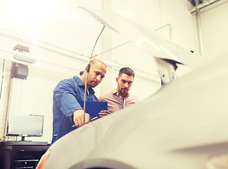 Image showing auto mechanic with clipboard and man at car shop