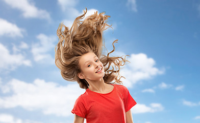 Image showing smiling teenage girl in red with long wavy hair