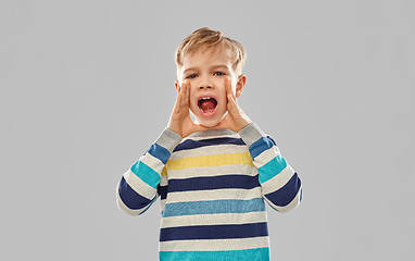 Image showing little boy in striped pullover calling someone