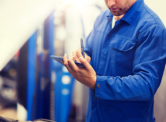 Image showing auto mechanic with clipboard at car repair shop