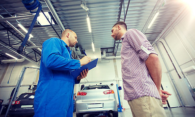 Image showing auto mechanic with clipboard and man at car shop