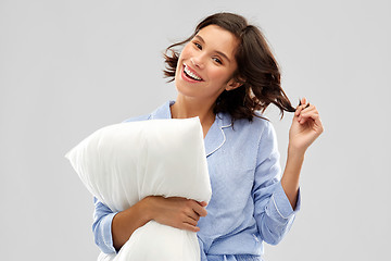 Image showing happy young woman in pajama hugging pillow