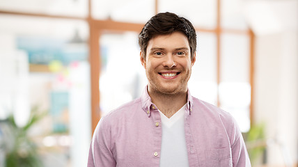 Image showing smiling young man over office room background