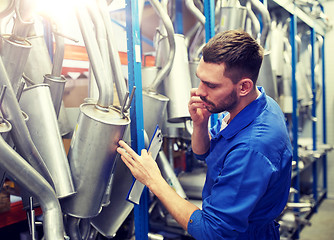 Image showing auto mechanic calling on phone at car shop