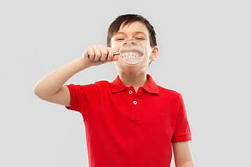 Image showing boy showing his teeth through magnifying glass