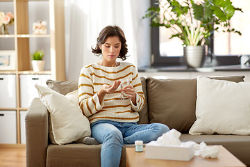 Image showing sick woman taking medicine with water at home