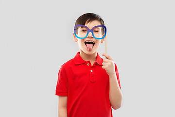 Image showing happy boy with big paper glasses showing tongue