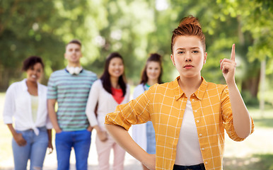 Image showing serious red haired teenage girl pointing finger up