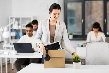 Image showing happy businesswoman with personal stuff at office