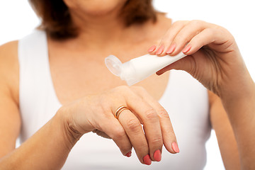 Image showing close up of senior woman applying hand cream