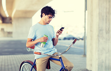 Image showing man with smartphone and earphones on bicycle