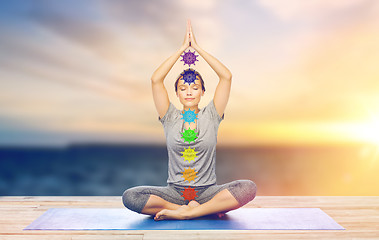 Image showing woman doing yoga in lotus pose with seven chakras