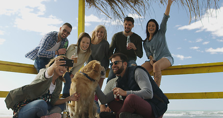 Image showing Group of friends having fun on autumn day at beach