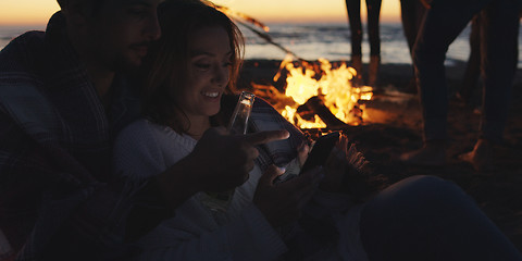 Image showing Couple enjoying bonfire with friends on beach