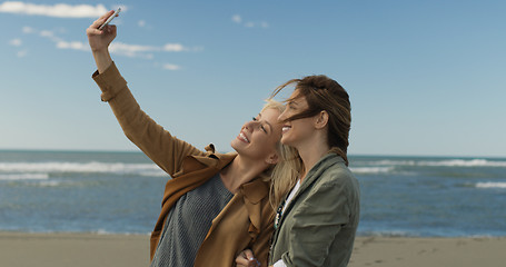 Image showing Girls having time and taking selfie on a beach