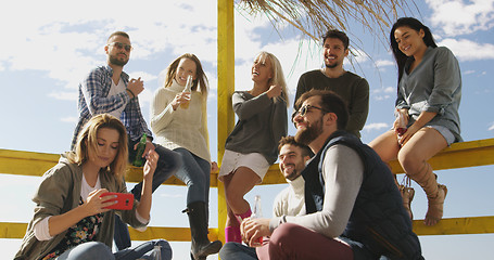 Image showing Group of friends having fun on autumn day at beach