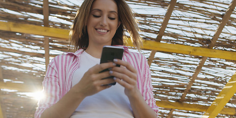 Image showing Smartphone Woman Texting On Cell Phone At Beach