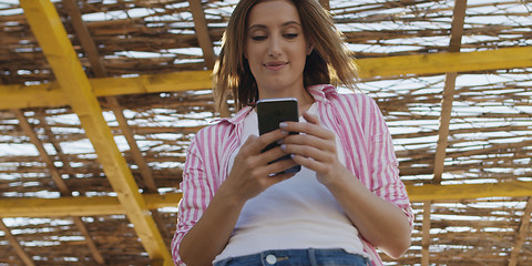 Image showing Smartphone Woman Texting On Cell Phone At Beach