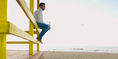 Image showing man drinking beer at the beach