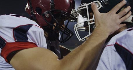 Image showing American football players knocking with helmets and having fun