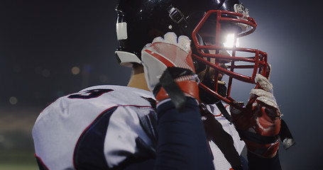 Image showing American Football Player Putting On Helmet on large stadium with