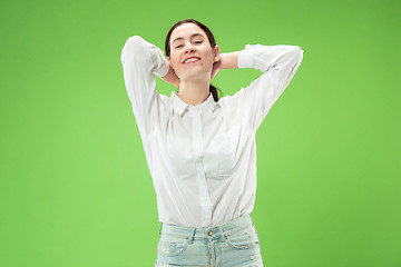 Image showing The happy business woman standing and smiling against green background.