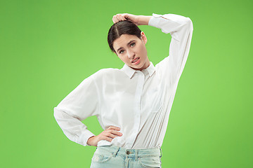 Image showing Beautiful woman looking suprised and bewildered isolated on green