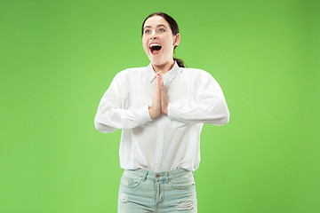 Image showing Beautiful woman looking suprised isolated on green