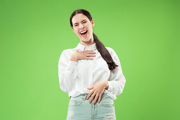 Image showing The happy business woman standing and smiling against green background.