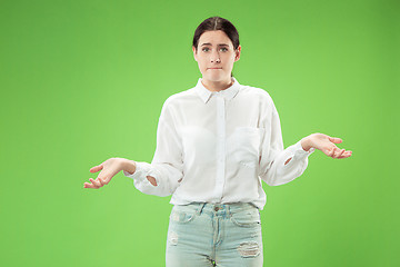 Image showing Beautiful woman looking suprised and bewildered isolated on green