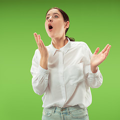 Image showing Beautiful woman looking suprised isolated on green