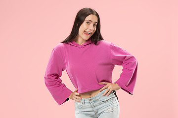 Image showing The happy business woman standing and smiling against pink background.