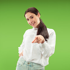 Image showing The happy business woman point you and want you, half length closeup portrait on green background.