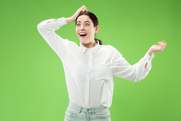 Image showing Beautiful woman looking suprised isolated on green