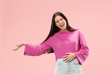 Image showing The happy business woman standing and smiling against pink background.