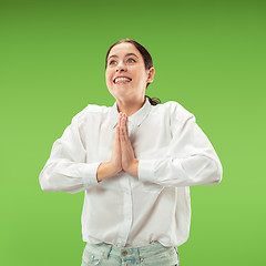 Image showing Beautiful woman looking suprised isolated on green