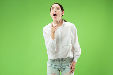 Image showing Beautiful woman looking suprised isolated on green