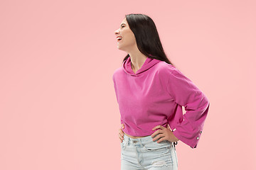 Image showing The happy business woman standing and smiling against pink background.