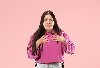 Image showing Beautiful female half-length portrait isolated on pink studio backgroud. The young emotional surprised woman