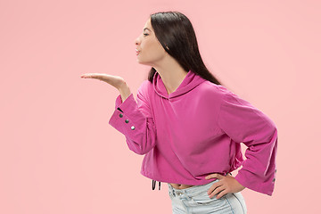 Image showing Portrait of attractive cute girl with bright makeup with kiss isolated over pink background